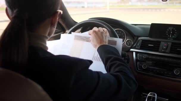 Eine Junge Autofahrerin Mit Brille Hält Auto Papierdokumente Der Hand — Stockvideo