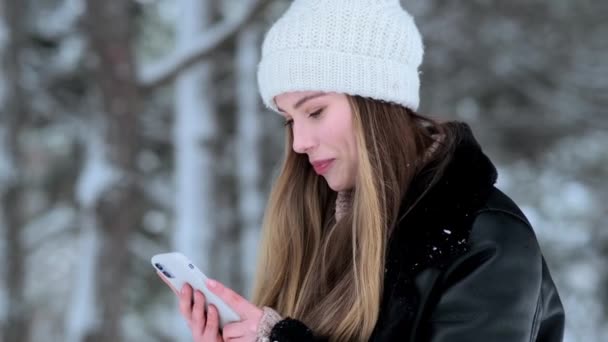 Eine Schöne Junge Frau Geht Winter Mit Ihrem Smartphone Nach — Stockvideo