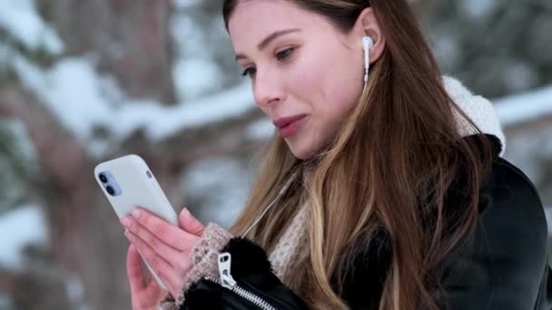 Eine Positive Junge Frau Mit Kopfhörern Benutzt Ihr Smartphone Während — Stockvideo