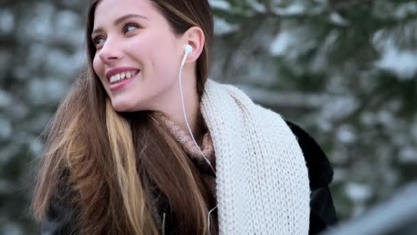 Gülümseyen Genç Bir Kadın Kışın Parkta Yürürken Yan Tarafa Bakıyor — Stok video