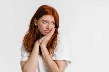 Ginger güzel kız poz veriyor ve beyaz arka planda tek başına bakıyor.