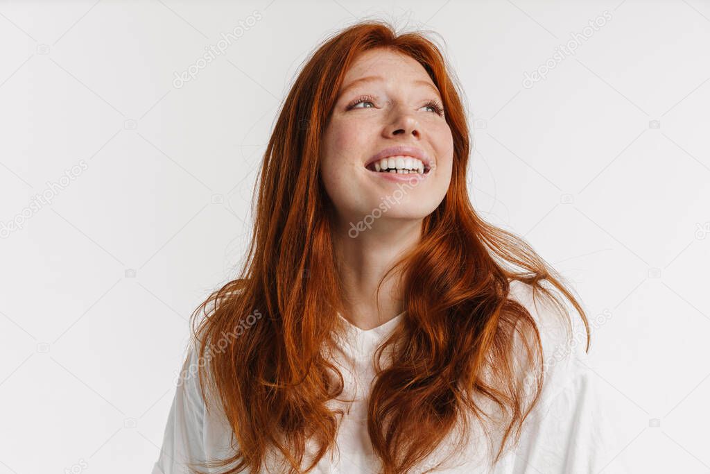 Ginger beautiful happy girl smiling and looking upward isolated over white background