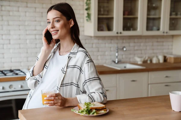 Happy Pregnant Woman Talking Cell Phone While Having Breakfast Cozy — стоковое фото