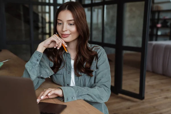 Hermosa Mujer Sonriente Que Trabaja Con Ordenador Portátil Mientras Está —  Fotos de Stock