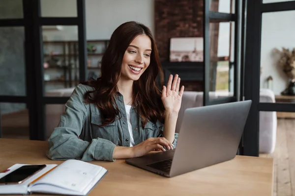 Hermosa Mujer Sonriente Saludando Mano Trabajando Con Ordenador Portátil Mientras — Foto de Stock