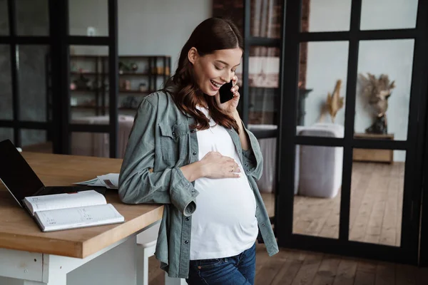 Mujer Embarazada Feliz Hablando Por Teléfono Celular Mientras Trabaja Con — Foto de Stock