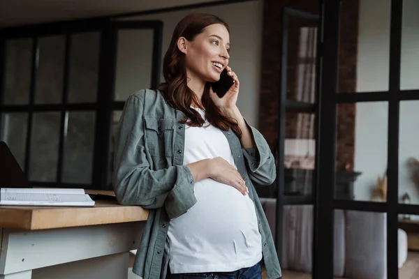 Mujer Embarazada Feliz Hablando Por Teléfono Celular Mientras Trabaja Con — Foto de Stock