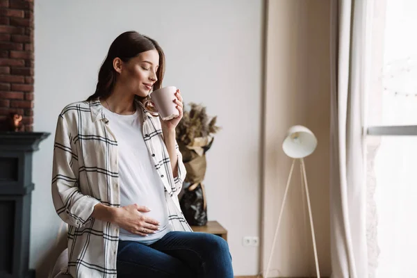 Vacker Glad Gravid Kvinna Ler Och Dricker Kaffe Medan Sitter — Stockfoto