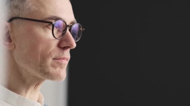 Şaşırmış bir adamın yakın çekim görüntüsü stüdyonun yan tarafına bakıyor.