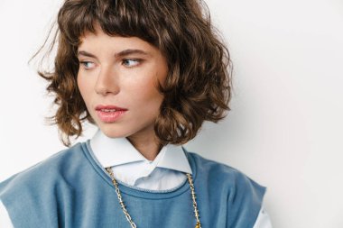 Beyaz arka planda yalnız başına poz veren beyaz güzel bir kız.