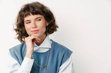 Ciddi, güzel bir kız beyaz arka planda izole edilmiş bir şekilde düşünüyor.