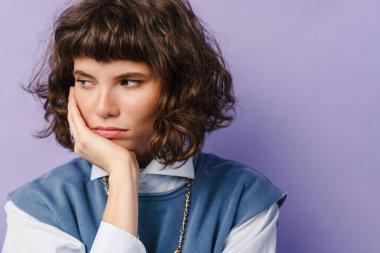 Mor arka planda izole edilmiş, ciddi, güzel bir kız.