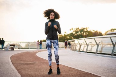Şehir köprüsünde spor yaparken spor yapan genç bir sporcu.