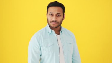 Rahat bir Hintli dans ediyor. Stüdyoda sarı arka planda.