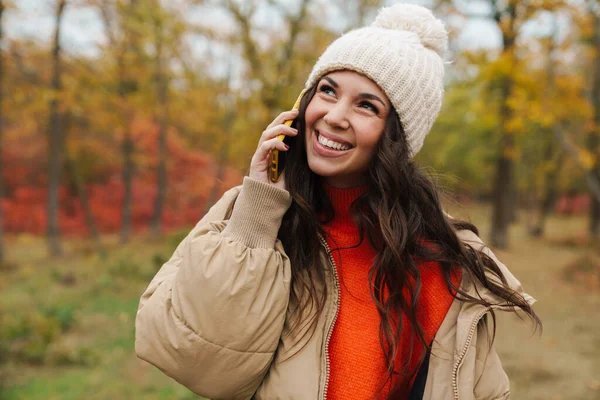 mutlu genç kadın cep telefonuyla sonbahar park