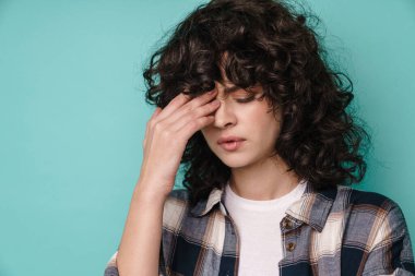Kafkasyalı mutsuz kıvırcık kız. Baş ağrısı var. Kameraya poz veriyor.