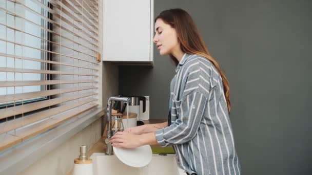 Seorang Wanita Muda Yang Menarik Adalah Mencuci Piring Dapur Rumah — Stok Video