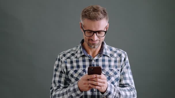Bel Homme Adulte Portant Des Lunettes Utilise Son Smartphone Isolé — Video