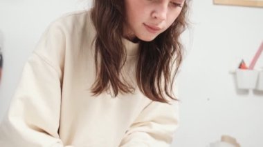 Kendine güvenen güzel bir kadın terzi tasarım stüdyosunda çalışırken kumaşı kesiyor.