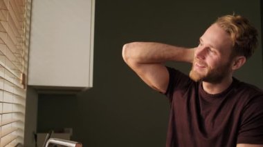 Olumlu bir adam sabahları mutfakta dikilirken pencereyi izliyor.