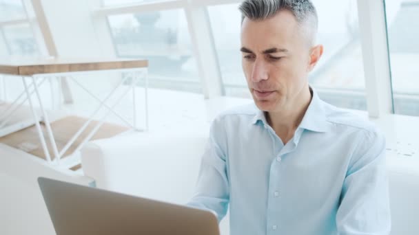 Een Glimlachende Volwassen Man Doet Winnaarsgebaar Terwijl Hij Zijn Laptop — Stockvideo