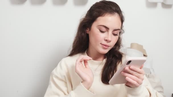 Smiling Young Woman Seamstress Using Her Smartphone Sitting Design Studio — Stock Video