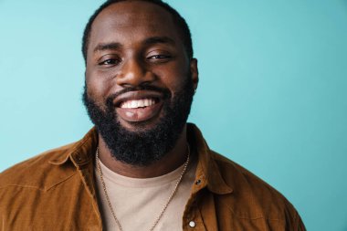 Mavi arka planda izole edilmiş mutlu, heyecanlı bir Afrikalı adama yaklaş.