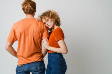 Portrait of beautiful young couple standing isolated over background, posing