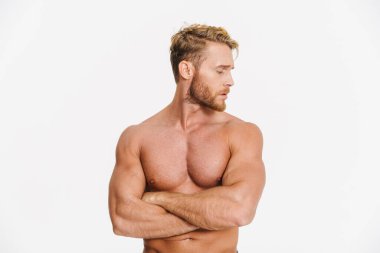 Beyaz arka planda kolları çapraz duran yakışıklı, beyaz gömleksiz adam.