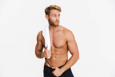 Beyaz arka planda izole edilmiş kameraya havluyla poz veren beyaz, beyaz, beyaz, üstsüz bir adam.