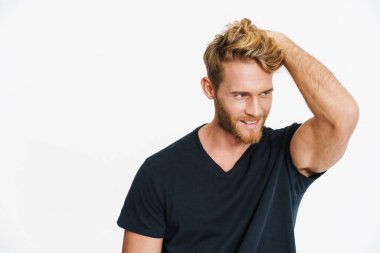 Beyaz arka planda izole edilmiş kameraya poz veren ve gülümseyen neşeli beyaz sarışın adam.