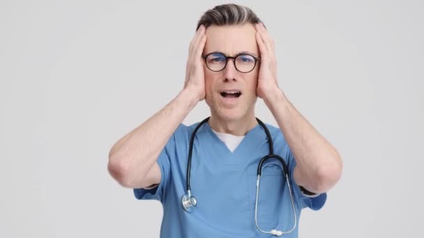 Шокований Старший Лікар Медичній Формі Торкається Його Руки Стоїть Ізольовано — стокове відео