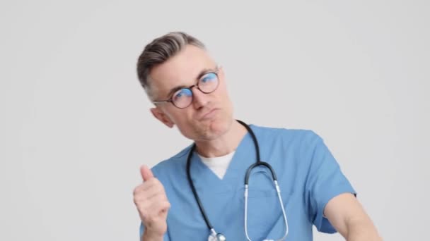 Szczęśliwy Starszy Lekarz Mundurze Medycznym Tańczy Szarym Tle Studio — Wideo stockowe