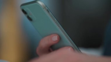 A close-up view of a woman is holding her smartphone