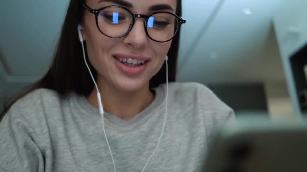 Позитивна Жінка Навушниками Використовує Свій Смартфон Сидячи Всередині Квартир — стокове відео