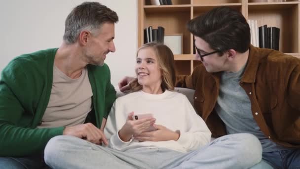 Smiling Gay Family Using Mobile Phone While Sitting Couch Home — Αρχείο Βίντεο