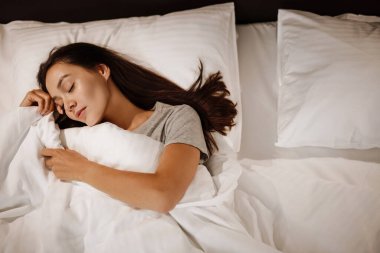 Esmer, beyaz, güzel bir kadın evde uyuyor.