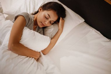 Esmer, beyaz, güzel bir kadın evde uyuyor.