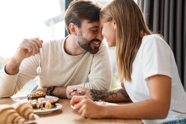 Güzel mutlu çift kahvaltılarını evde yapıyorlar, kucaklaşıyorlar.