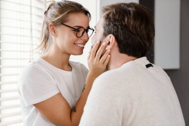 Güzel mutlu beyaz çift içeride gülüyor ve sarılıyor.