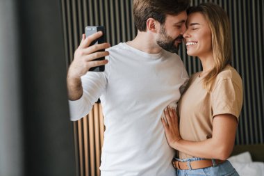 Aşık çift hafta sonunun tadını çıkarıyor ve yatak odasında selfie çekiyor.