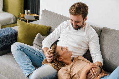 Mutlu çift evde kanepede dinleniyor.