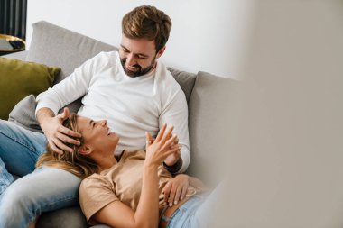 Mutlu çift evde kanepede dinleniyor.