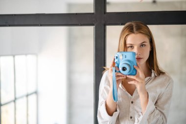 Kafkasyalı güzel bir kız. Evinde eski bir kamerayla fotoğraf çekiyor.
