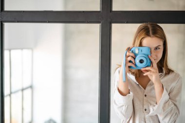Kafkasyalı güzel bir kız. Evinde eski bir kamerayla fotoğraf çekiyor.