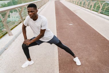 Rahat Afrikalı sporcu köprüde dikilirken geriniyor.