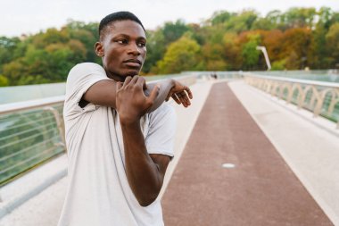 Rahat Afrikalı sporcu köprüde dikilirken geriniyor.