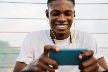 Köprüde cep telefonu kullanan çekici Afrikalı genç bir adam.