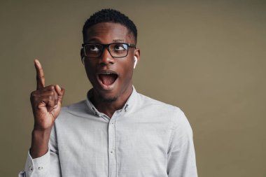 Beyaz gömlekli mutlu Afrikalı iş adamı. Gri arka planda izole edilmiş fotokopi alanını sunuyor.