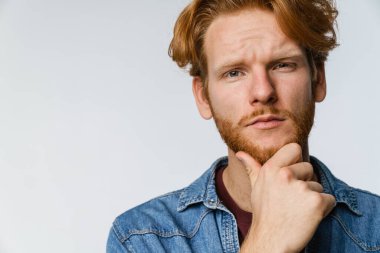 Beyaz arka planda izole edilmiş, poz veren ve kameraya bakan yakışıklı bir adam.